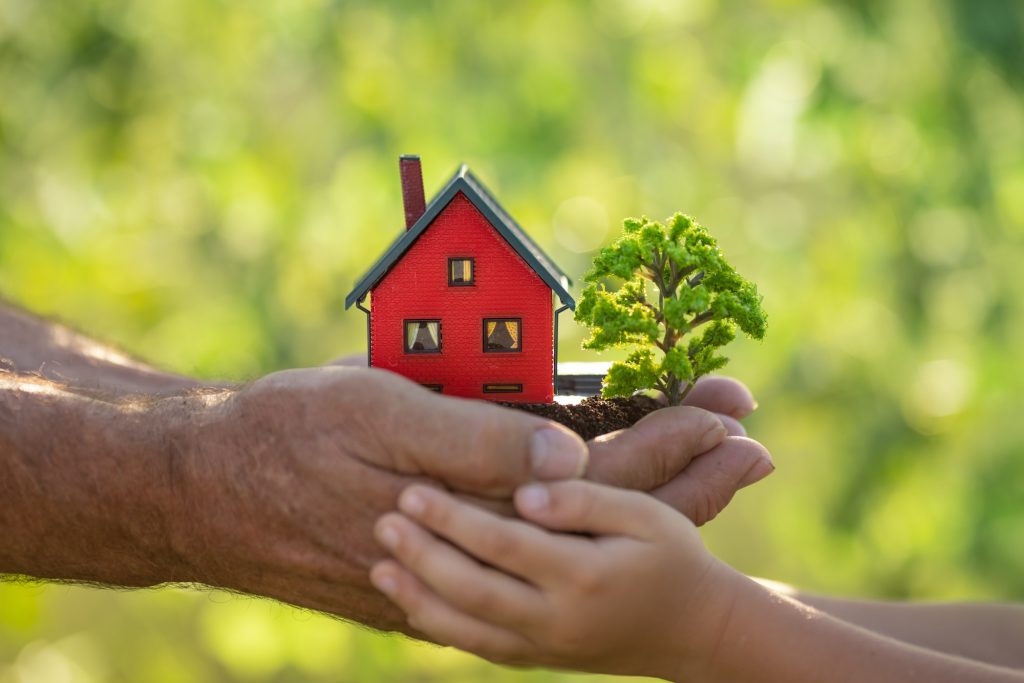 Family holding model of house and tree in hands